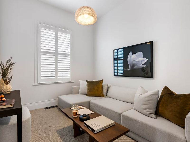Bright living room featuring framed botanical artwork above a light grey sectional