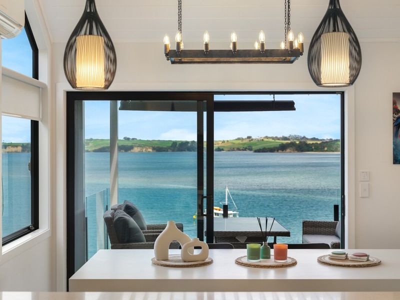 Kitchen island framed by pendant lighting, with sea and hillside views beyond