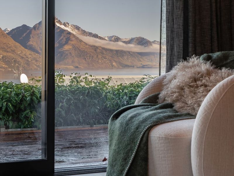 Living room armchair with a green throw, looking out to mountain and lake views